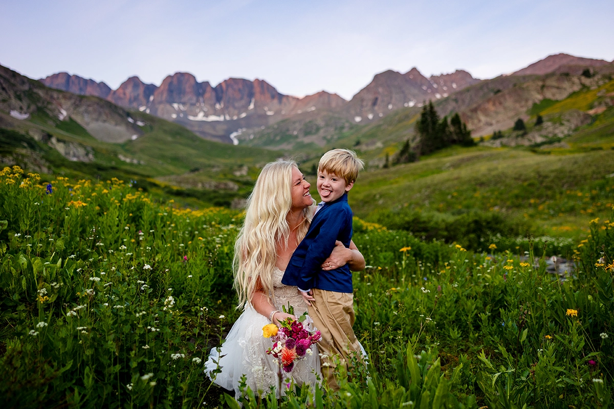 A bride and her son on her wedding day in a field of flowers near American Basin, Colorado
