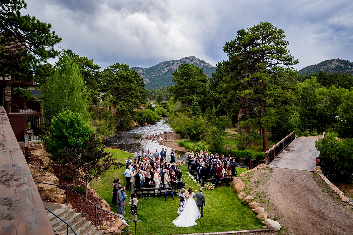 An aerial image of a bride walking down the aisle to meet her groom at a wedding venue in Estes Park