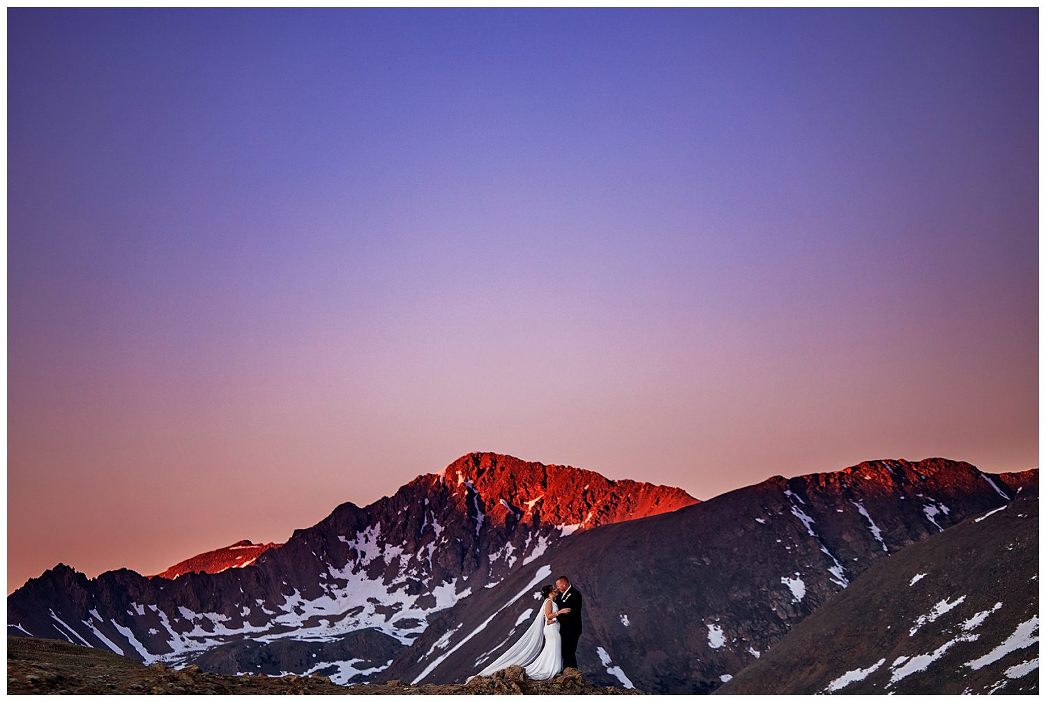 A bride and groom embracing at sunset at the top of Independence Pass near Aspen Colorado
