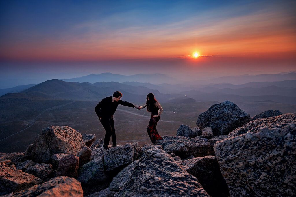 A couple traversing a ridgeline on Mt Blue Sky in Colorado at Sunrise for their elopement 