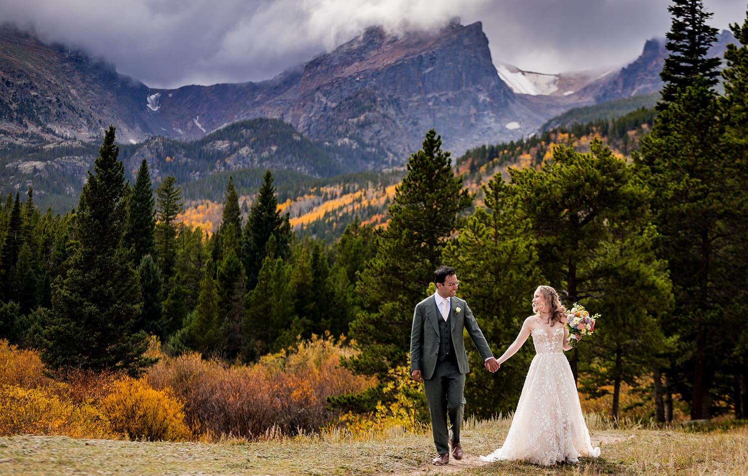 A couple walking hand in hand at Storm Pass in Estes Park Colorado during peak fall season