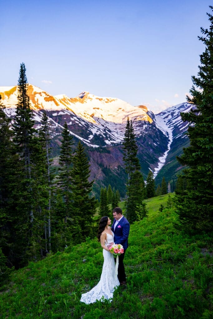 A bride and a groom looking at one another for couple's portraits in an alpine field above Crested Butte, Colorado