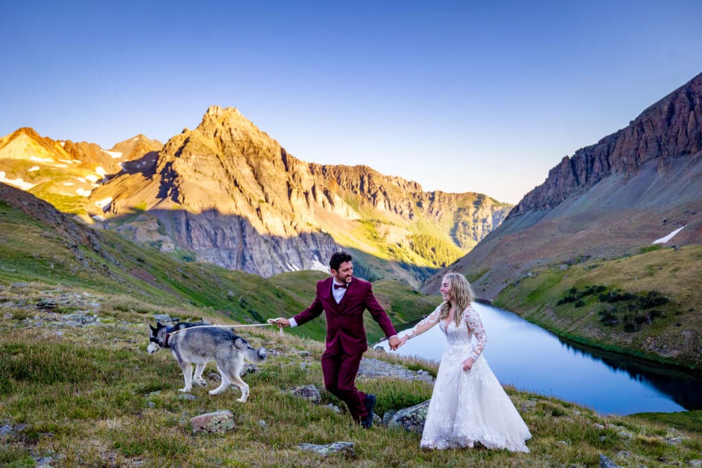 A bride and groom walking their dog at the second lakes overlook near Lower, Middle, and Uppper Blue lakes hiking trail in Ridgway, Colorado.