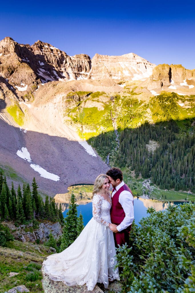 A bride and groom embracing on their wedding day overlooking Lower Blue Lakes just outside of Ridgway, Colorado