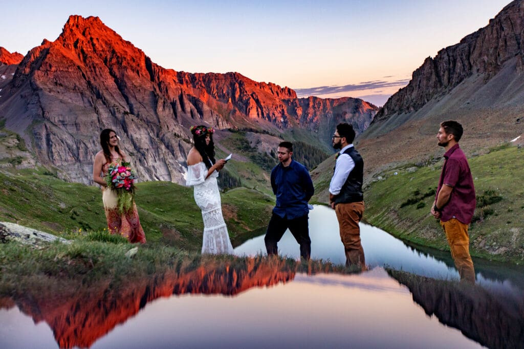 A couple saying their vows to one another overlooking Blue Lakes near Ridgway, Colorado with three of their closest friends at sunrise.