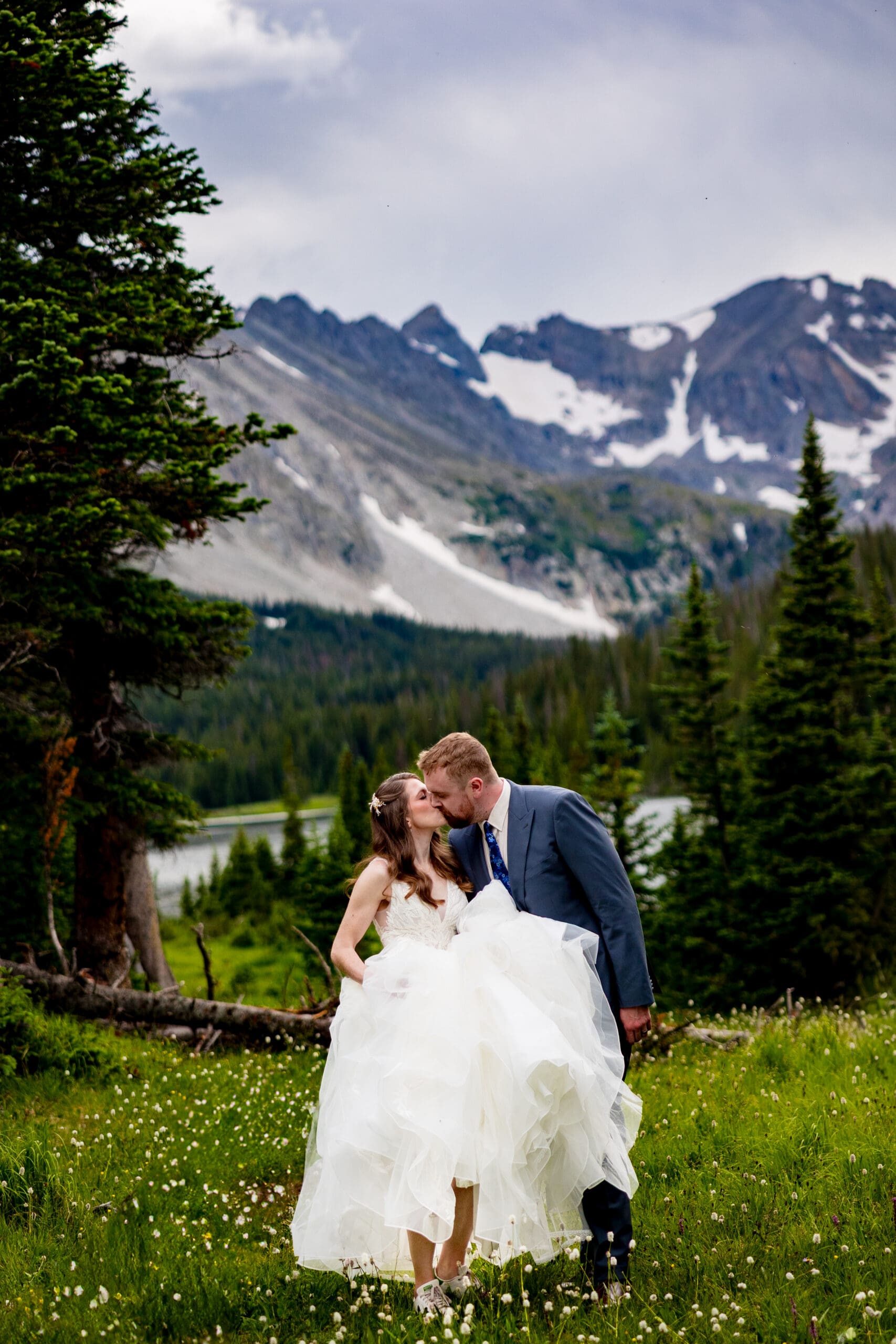 a couple kissing as they're walking near Lake Isabelle during the summertime