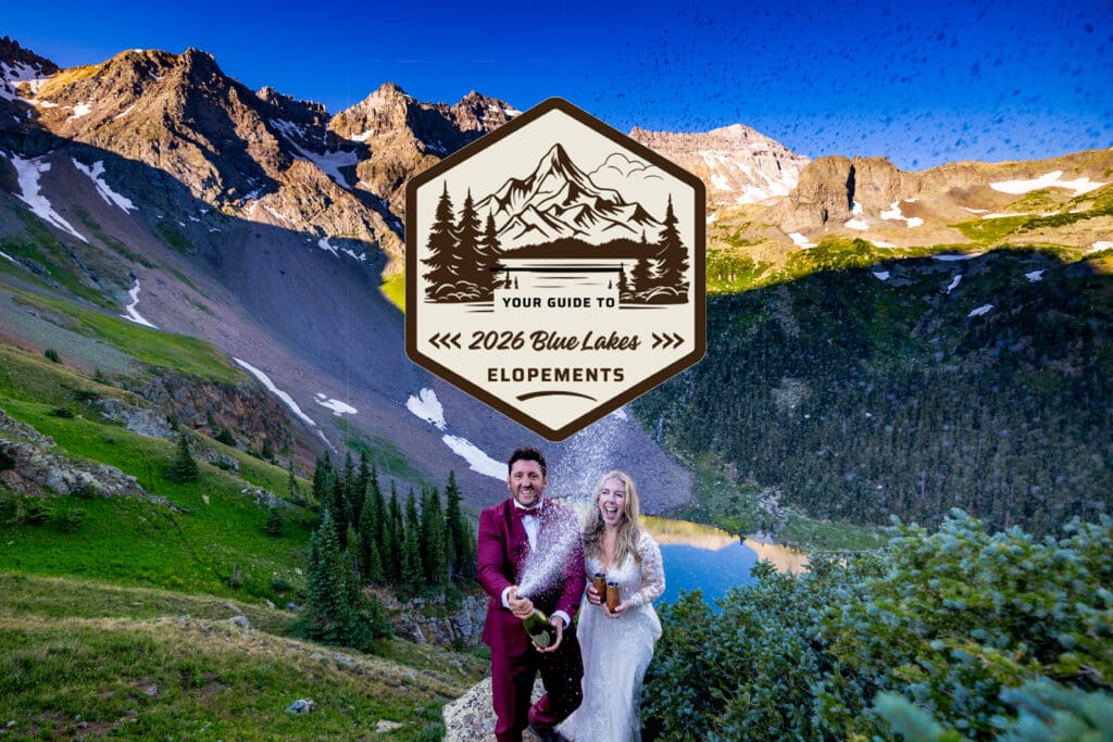 A bride and a groom are spraying a bottle of champagne in celebration of their elopement at Blue Lakes outside Ridgway, Colorado