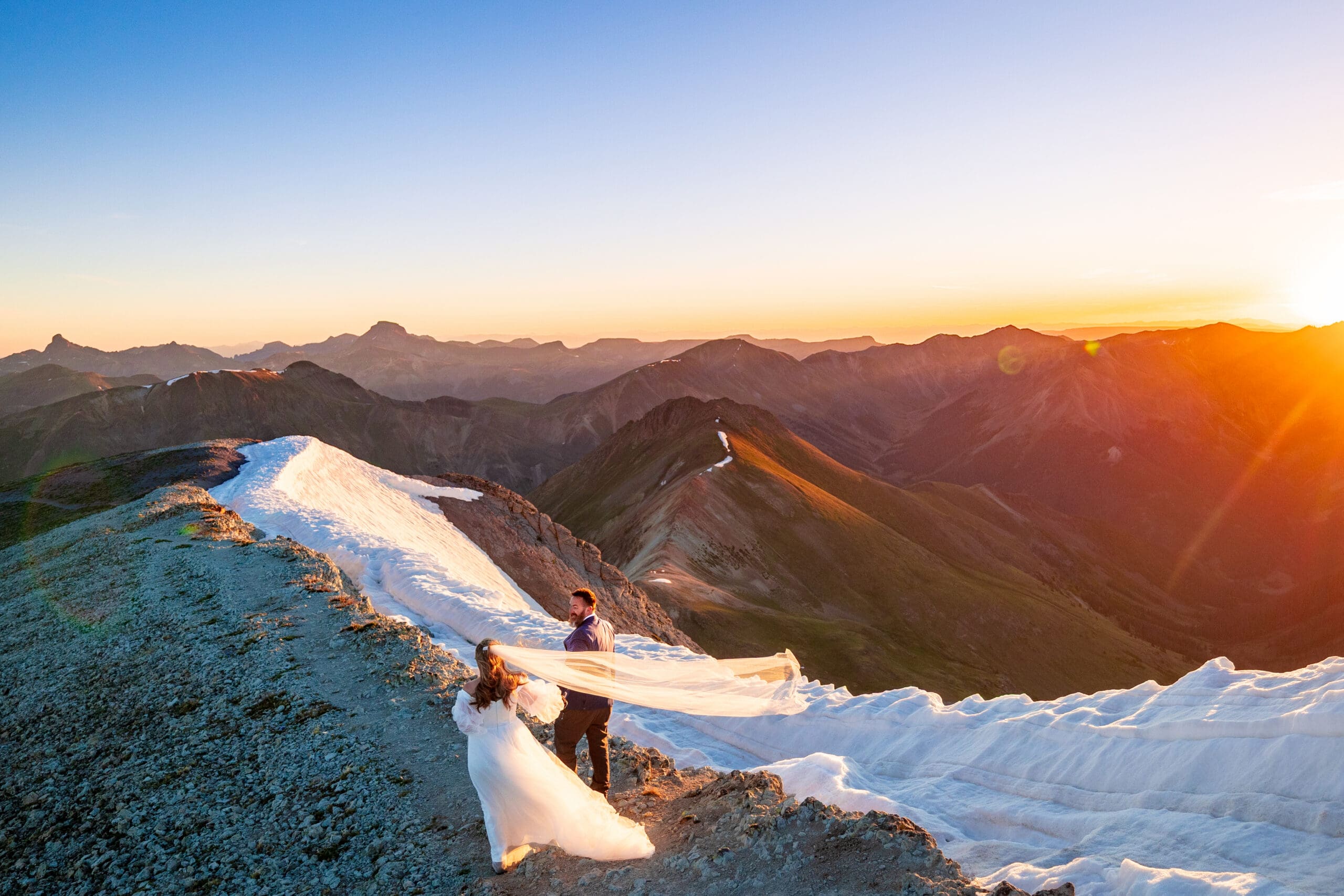 A couple hiking on their wedding day on Handies Peak at sunrise